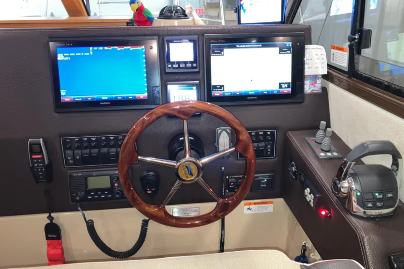 Slide: The Image of 2017 Cutwater C-30 Sedan helm with Garmin displays, wooden steering wheel, and control panel. - 55
