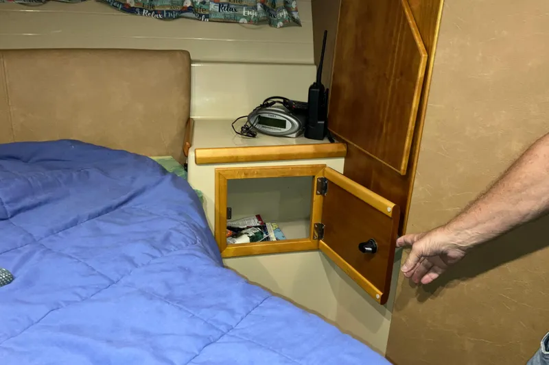 Slide: The Image of 2017 Cutwater C-30 Sedan cabin with open wooden cabinet and blue bedding. - 80
