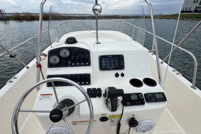 Slide: The Image of 2016 Boston Whaler 210 Montauk boat dashboard with steering wheel and navigation controls. - 14