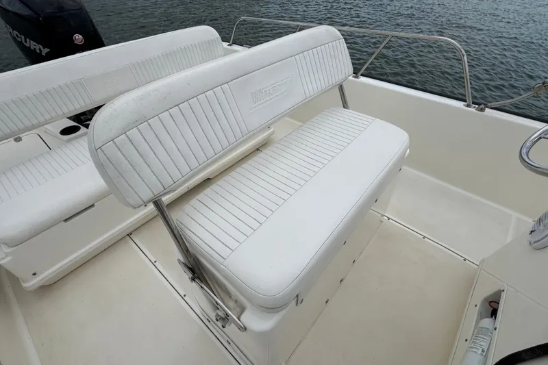 Slide: The Image of 2016 Boston Whaler 210 Montauk boat interior with white seating and railing. - 23