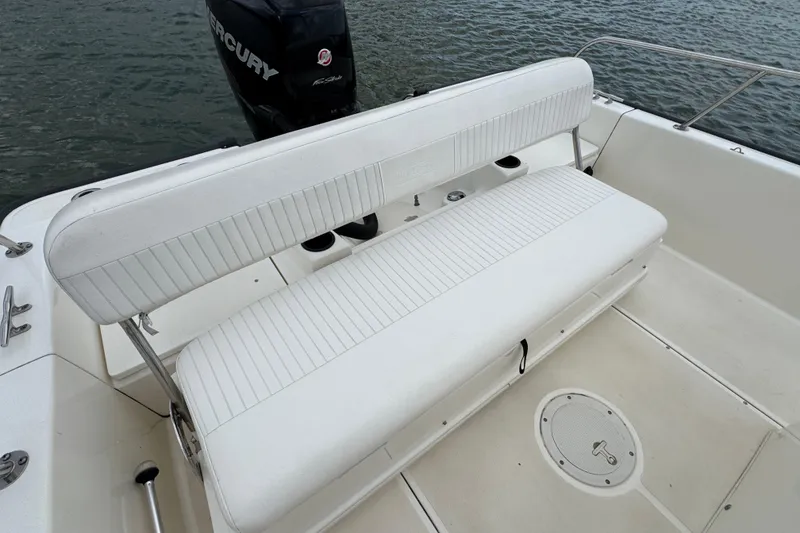Slide: The Image of 2016 Boston Whaler 210 Montauk boat interior with white seating and Mercury engine. - 24