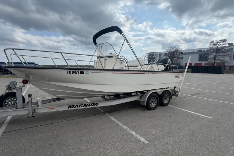 Slide: The Image of 2016 Boston Whaler 210 Montauk boat on trailer in parking lot under cloudy sky. - 7