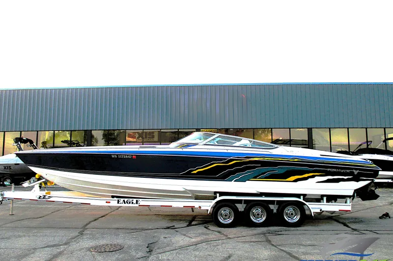 The Image of 2005 Formula 353 FASTech speedboat on trailer, vibrant graphics, parked outside a showroom. - 0