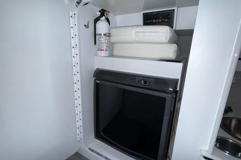 Slide: The Image of 2005 Formula 353 FASTech interior with fire extinguisher, cushions, and mini fridge. - 12