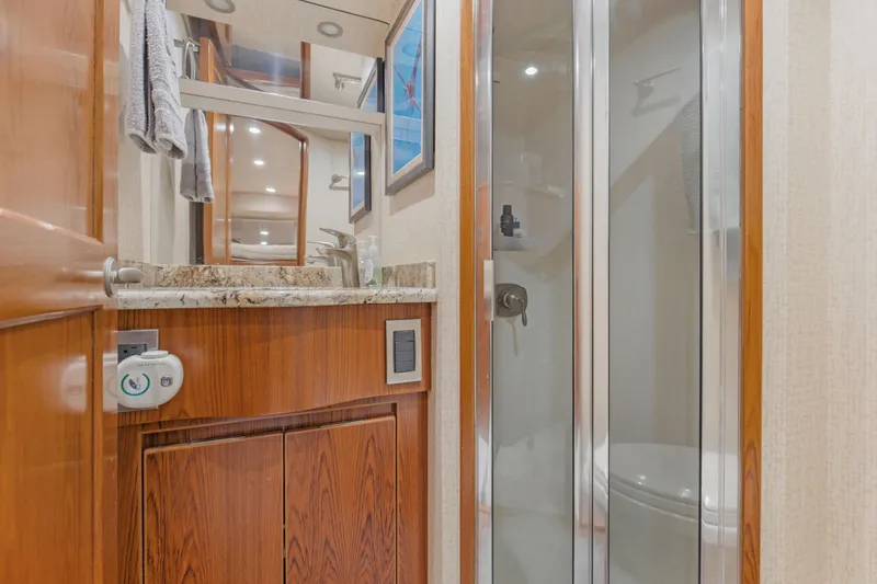 Slide: The Image of Luxurious bathroom in 2015 Viking 70 Convertible yacht with wood cabinetry and glass shower. - 44