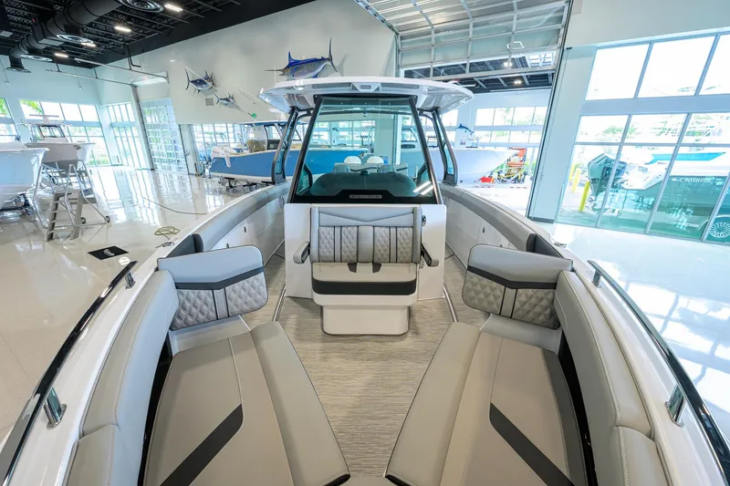 Slide: The Image of 2026 Monterey Elite 30 OB boat interior with luxurious seating in a showroom. - 19