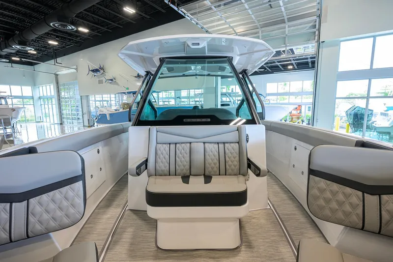Slide: The Image of 2026 Monterey Elite 30 OB boat interior with luxurious seating in a showroom. - 20