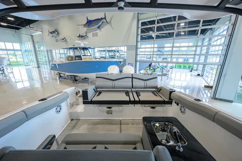 Slide: The Image of Interior view of 2026 Monterey Elite 30 OB boat in a showroom with marine decor. - 34