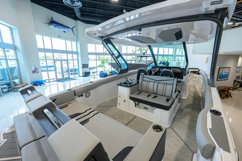 Slide: The Image of 2026 Monterey Elite 30 OB boat interior, showcasing luxurious seating and modern design in a showroom. - 37