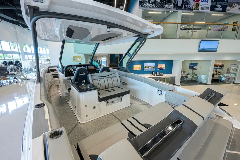 Slide: The Image of 2026 Monterey Elite 30 OB luxury boat interior with modern seating and sleek design in showroom. - 40