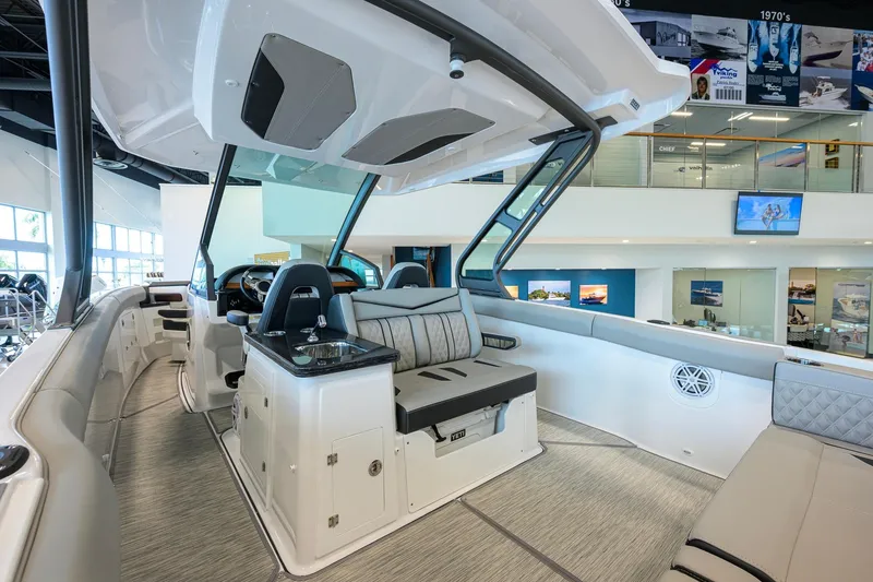 Slide: The Image of 2026 Monterey Elite 30 OB boat interior with modern seating and helm in showroom. - 41