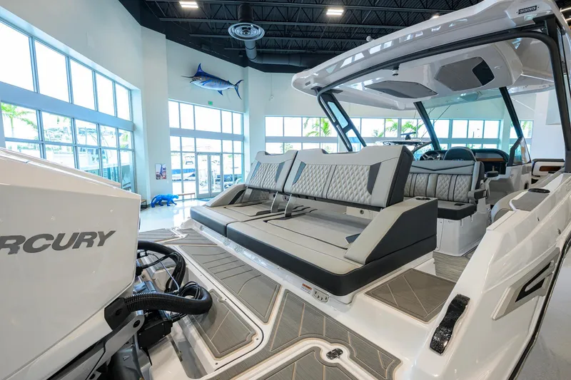 Slide: The Image of 2026 Monterey Elite 30 OB boat interior with luxurious seating and Mercury engine in showroom. - 47