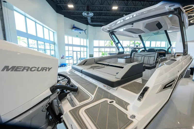 Slide: The Image of 2026 Monterey Elite 30 OB boat with Mercury engine in showroom, featuring luxurious seating. - 48