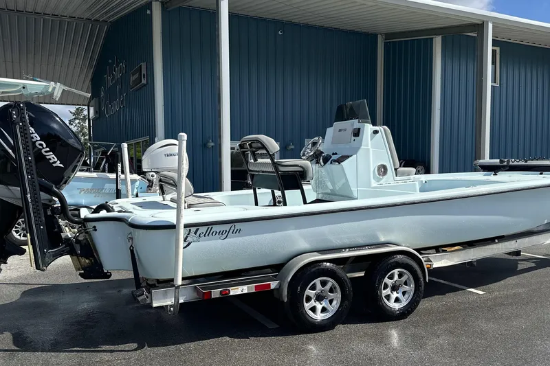 Slide: The Image of 2017 Yellowfin 24 Bay CE boat on trailer, parked outside a blue building. - 17