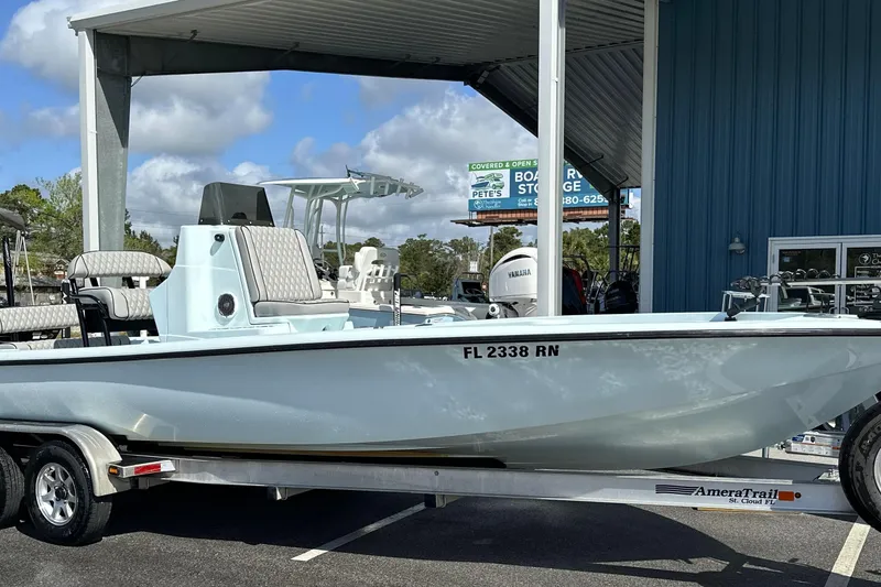Slide: The Image of 2017 Yellowfin 24 Bay CE boat on trailer, parked at a marina under a canopy. - 19