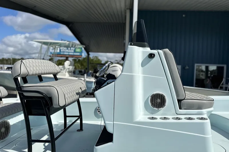 Slide: The Image of 2017 Yellowfin 24 Bay CE boat interior with cushioned seating and steering console. - 2