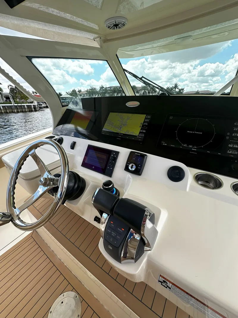 Slide: The Image of 2020 Scout 380 LXF boat helm with advanced navigation controls and scenic water view. - 15
