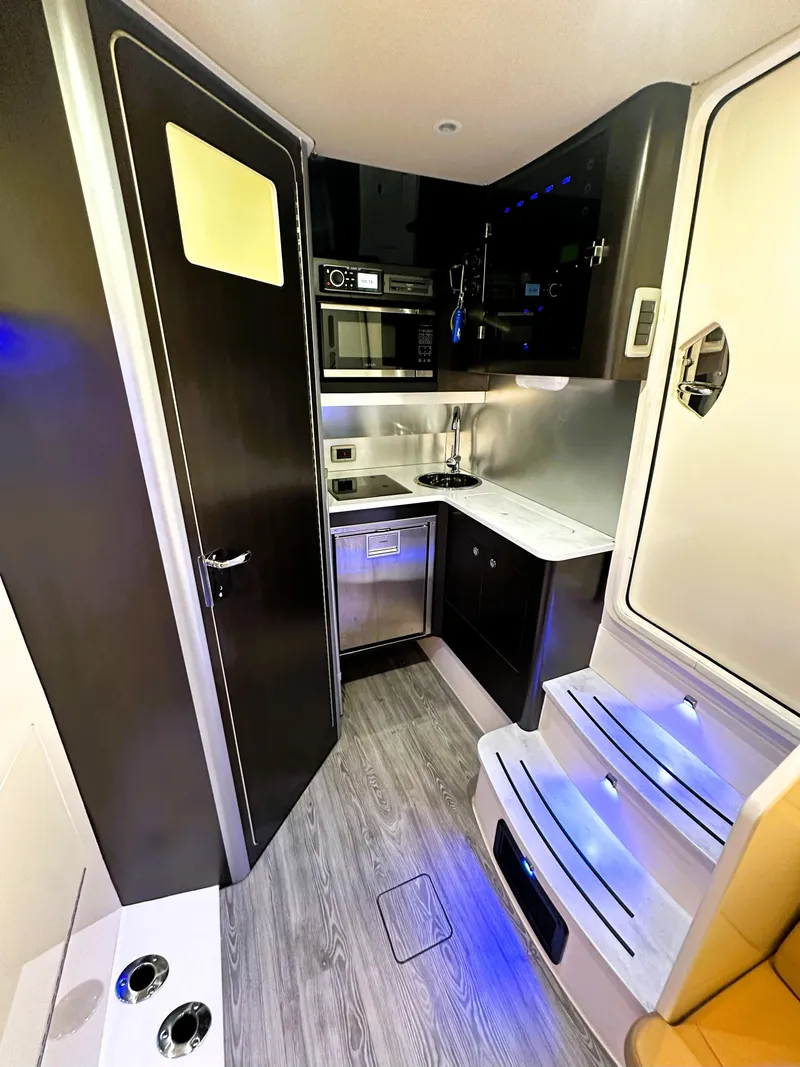 Slide: The Image of 2020 Scout 380 LXF interior with modern kitchen, sleek cabinetry, and ambient lighting. - 20