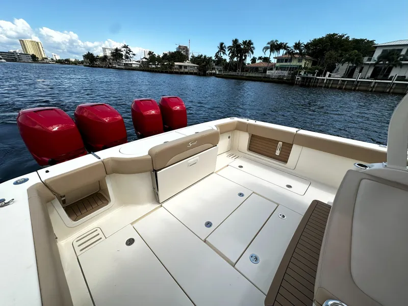 Slide: The Image of 2020 Scout 380 LXF boat with red engines, docked by waterfront homes. - 3