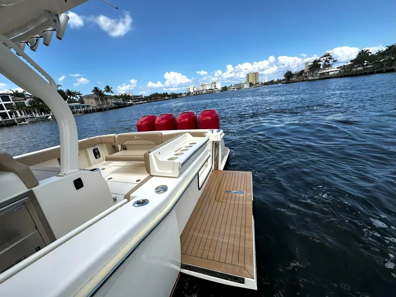 Slide: The Image of 2020 Scout 380 LXF boat on water, featuring spacious deck and scenic waterfront view. - 9