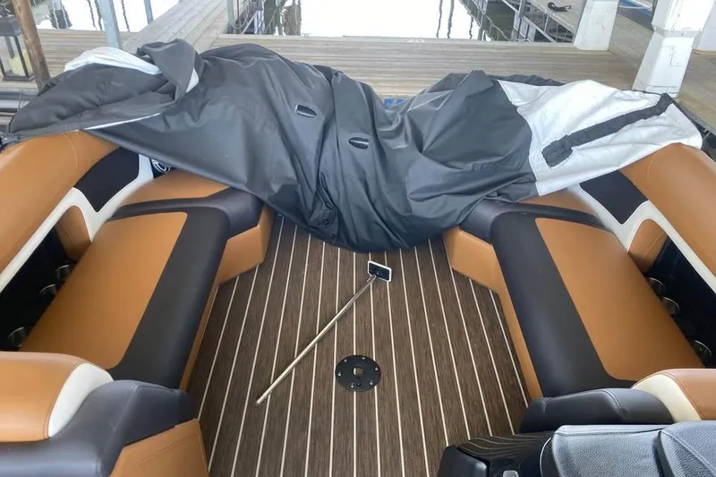 Slide: The Image of 2025 Premier Solaris 230RL boat interior with brown seating and wooden flooring. - 10