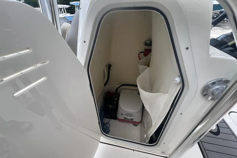 Slide: The Image of 2024 Key West 203 FS boat interior storage compartment with portable toilet. - 14