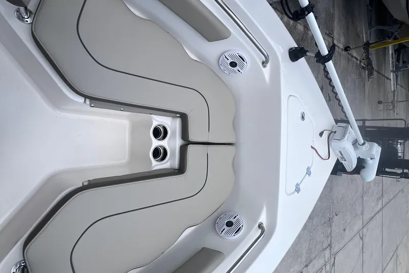 Slide: The Image of 2024 Key West 203 FS boat interior with seating and speakers, docked on concrete. - 17