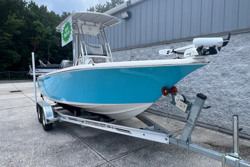 Slide: The Image of 2024 Key West 203 FS boat on trailer, vibrant blue hull, parked outdoors. - 2