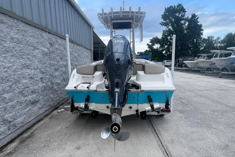 Slide: The Image of 2024 Key West 203 FS boat with outboard motor, parked near a marina. - 4