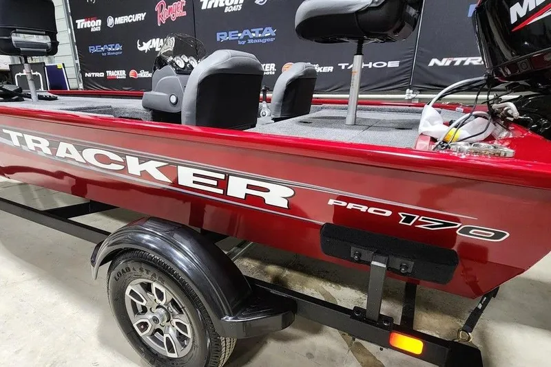 Slide: The Image of 2026 Tracker Pro 170 boat in showroom, red exterior, on trailer. - 11