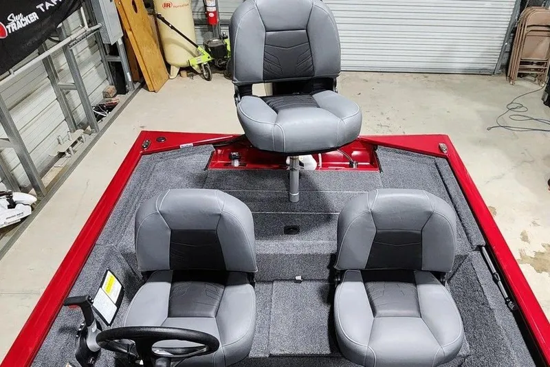 Slide: The Image of 2026 Tracker Pro 170 boat interior with three gray seats in a garage setting. - 6