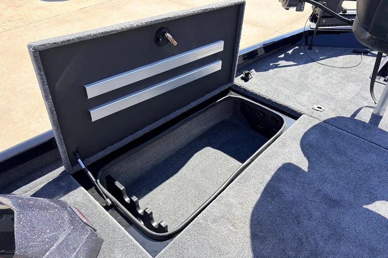 Slide: The Image of Open storage compartment in 2026 Ranger RT198P boat, featuring carpeted interior and organized layout. - 18