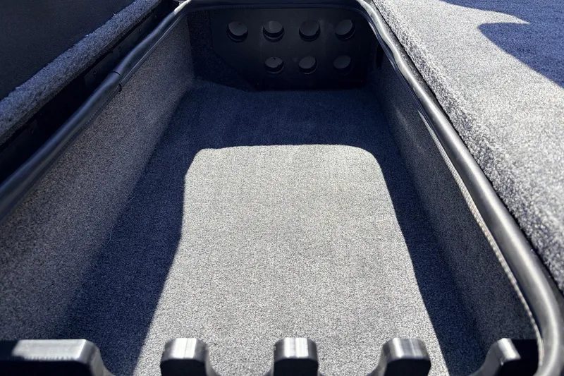 Slide: The Image of 2026 Ranger RT198P boat storage compartment with carpeted interior and rod holders. - 19