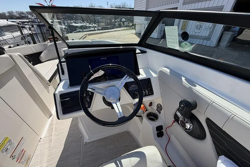 Slide: The Image of 2021 Sea Ray SPX 230 boat cockpit with steering wheel and control panel. - 16
