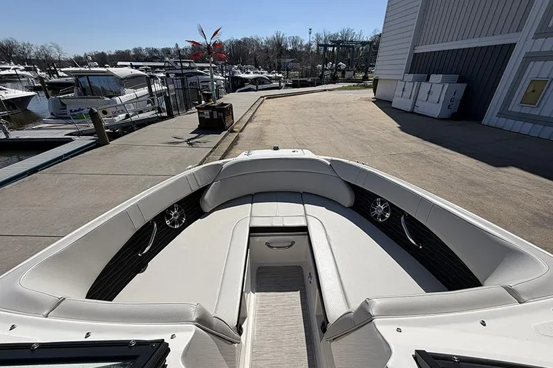 Slide: The Image of 2021 Sea Ray SPX 230 boat interior at marina dock, showcasing seating and storage. - 18