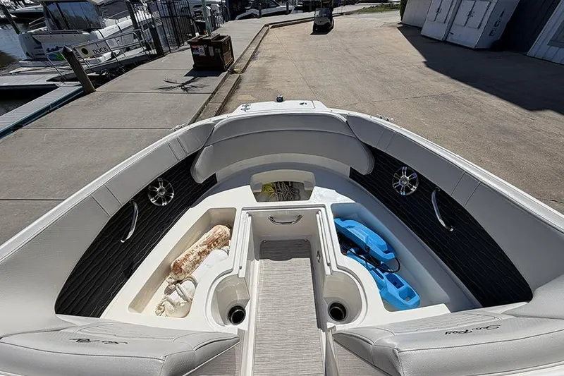 Slide: The Image of 2021 Sea Ray SPX 230 boat interior with seating and storage compartments at a marina. - 19