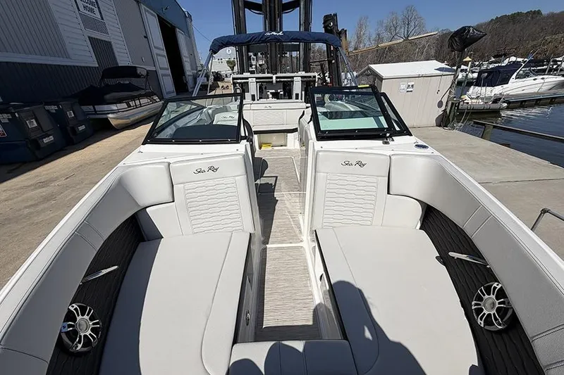 Slide: The Image of 2021 Sea Ray SPX 230 boat interior with white seating at a marina. - 21
