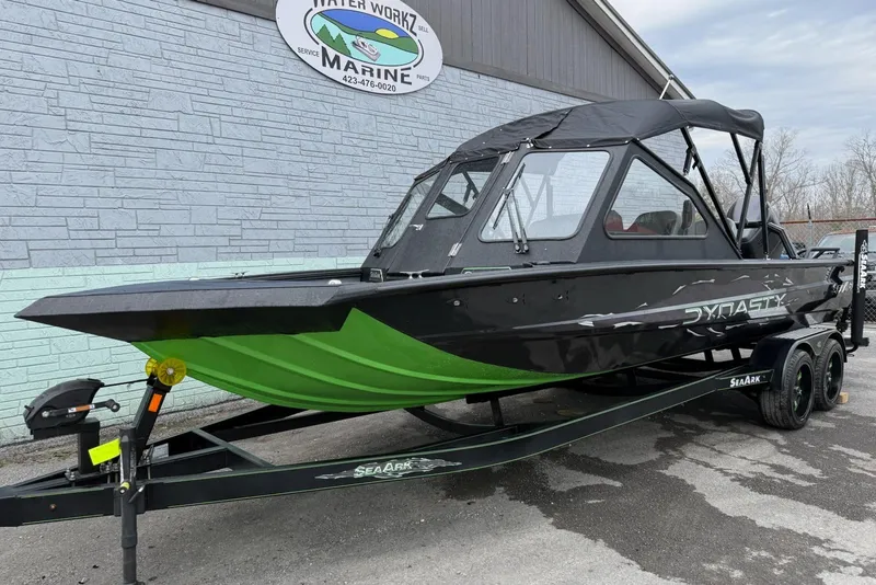 The Image of 2026 SeaArk Dynasty 2.0 boat with green hull on trailer, parked outside Water Works Marine. - 0