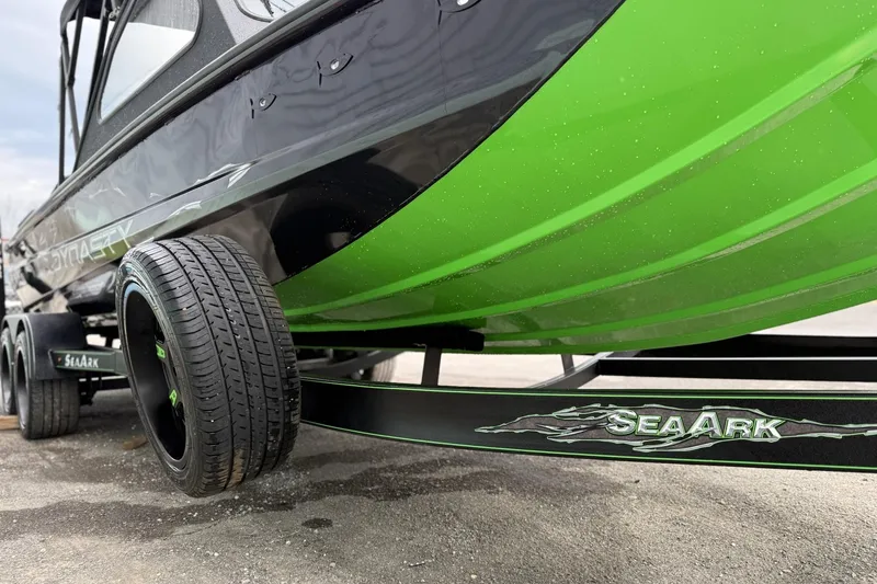 Slide: The Image of 2026 SeaArk Dynasty 2.0 boat on trailer, featuring sleek green and black design. - 10