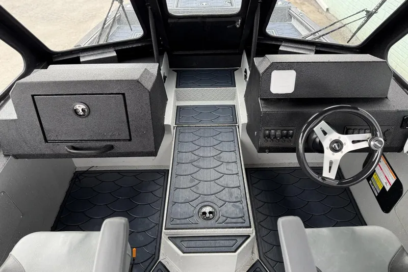 Slide: The Image of Interior of 2026 SeaArk Dynasty 2.0 boat with steering wheel and storage compartments. - 14