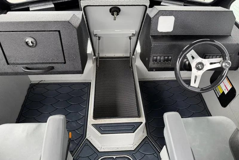 Slide: The Image of Interior of 2026 SeaArk Dynasty 2.0 boat, featuring steering wheel and storage compartments. - 15