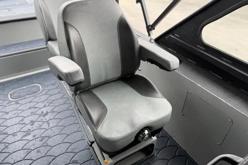 Slide: The Image of Seat inside 2026 SeaArk Dynasty 2.0 boat, featuring gray upholstery and armrests. - 16