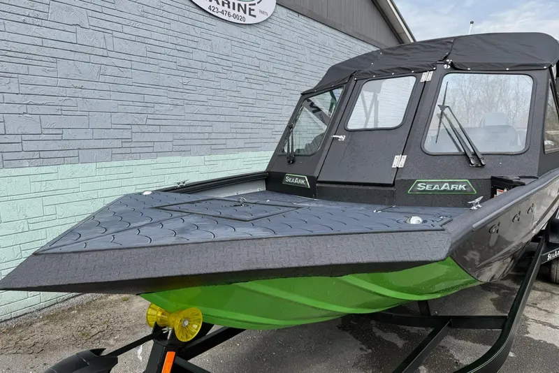 Slide: The Image of 2026 SeaArk Dynasty 2.0 boat with sleek design and green hull, parked outdoors. - 3