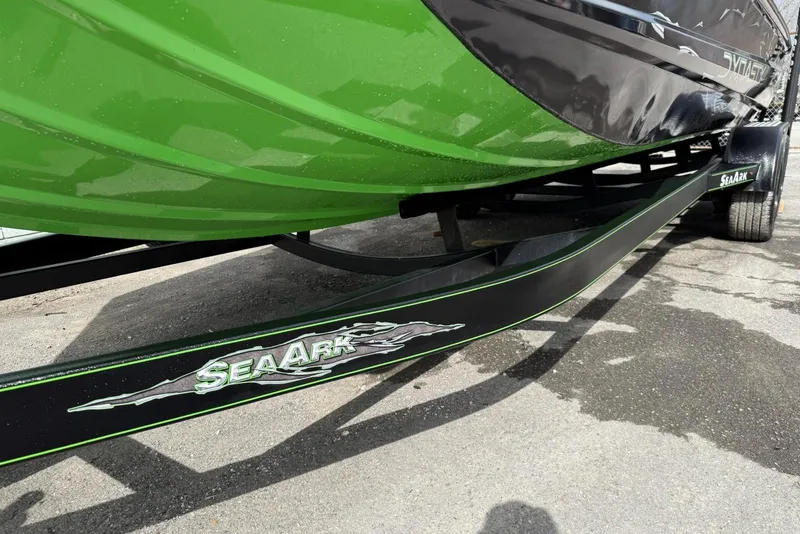 Slide: The Image of 2026 SeaArk Dynasty 2.0 boat with green and black design on a trailer. - 5