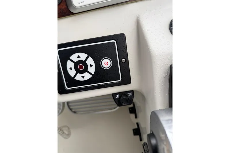 Slide: The Image of Control panel on a 1997 Larson Cabrio 310 Mid-Cabin boat, featuring directional buttons. - 13