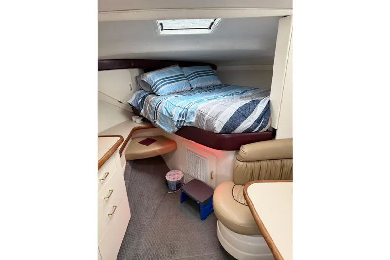 Slide: The Image of 1997 Larson Cabrio 310 Mid-Cabin interior with cozy bed and seating area. - 17