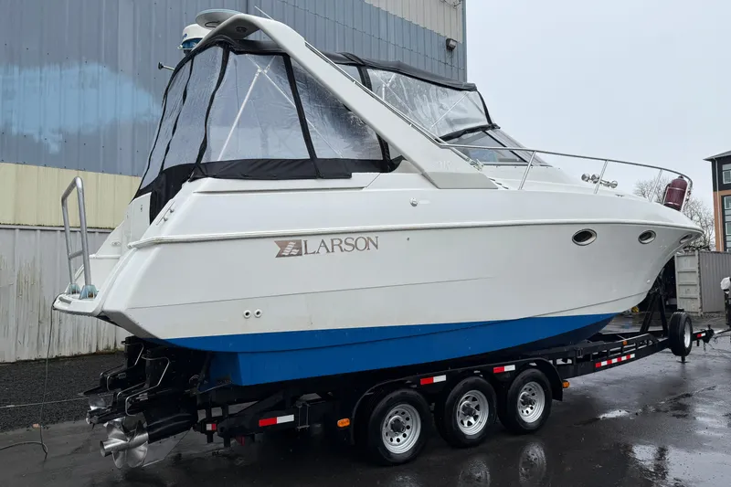 Slide: The Image of 1997 Larson Cabrio 310 Mid-Cabin boat on trailer, white hull with blue bottom. - 2