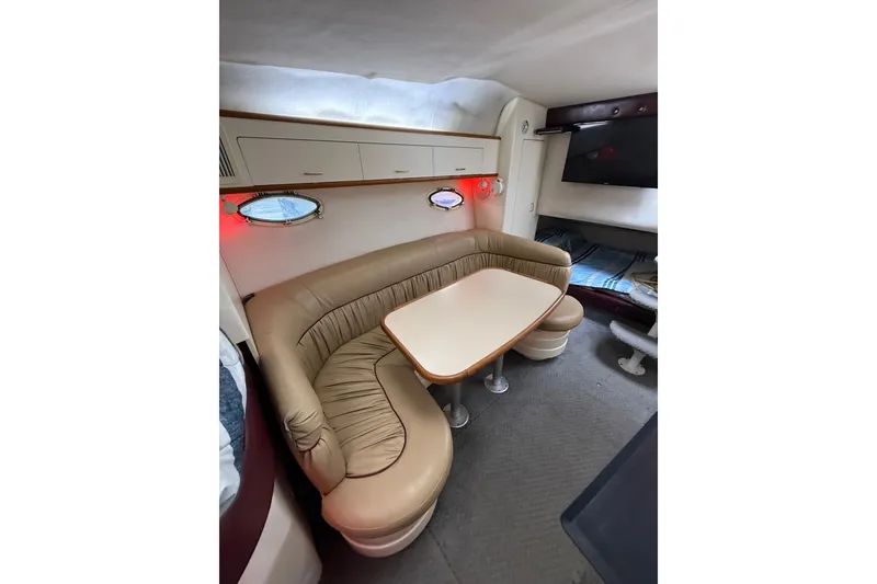 Slide: The Image of Interior of 1997 Larson Cabrio 310 Mid-Cabin with beige seating and table. - 20