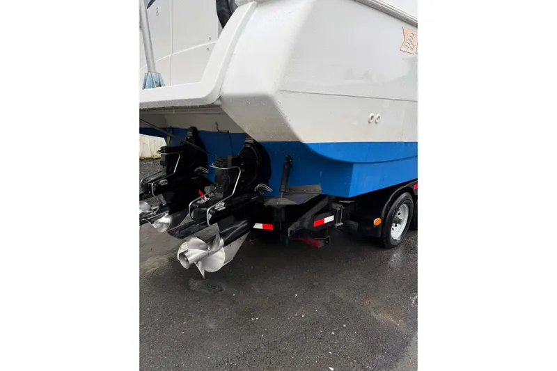 Slide: The Image of 1997 Larson Cabrio 310 Mid-Cabin boat on trailer, showing dual propellers. - 3