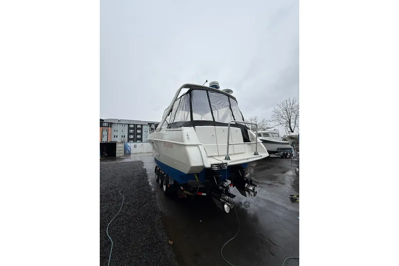 Slide: The Image of 1997 Larson Cabrio 310 Mid-Cabin boat on a wet dock, rear view. - 5